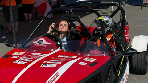 Jade, who is blind, sat in the driver's seat of s small red track car, with another driver sat in the passengers seat.