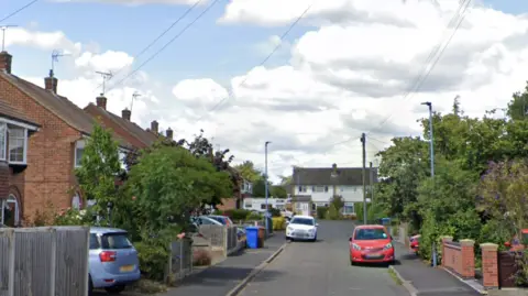 Google A suburban cul-de-sac with cars parked outside houses