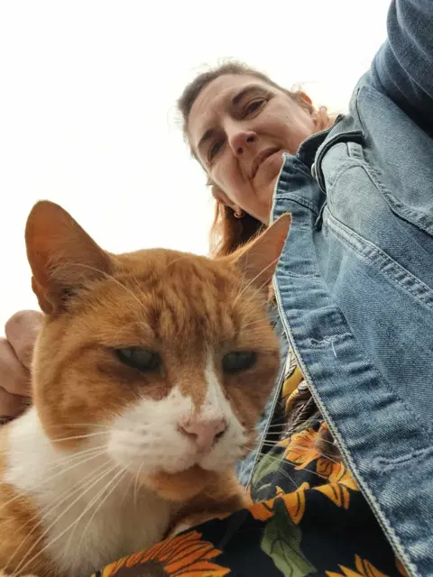 Susan Guy Photography A selfie photo taken by a woman with a white and ginger cat on her lap enjoying a stroke