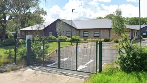 Google Glenwood School is a relatively flat, single-storey building. It has a metal fence out the front.