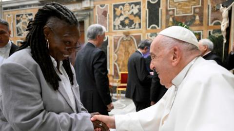 Whoopu Goldberg shakes hands with Pope Francis