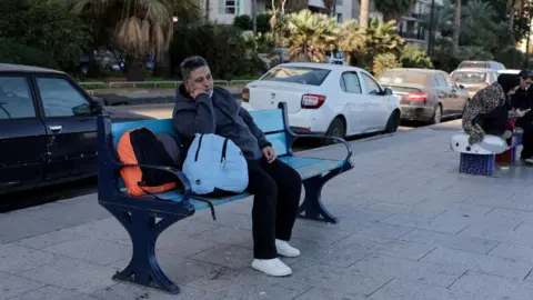 Reuters A displaced Lebanese man sits on a bench on Beirut's seafront, Lebanon, following a series of Israeli strikes in response to Hezbollah rocket fire (2 March 2026)