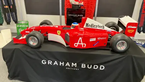 A red ferrari replica positioned on a table covered by a black cloth