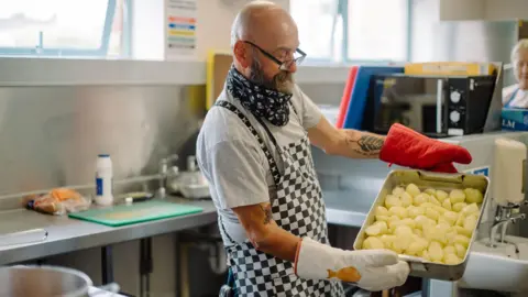 The Salvation Army A cook in a Salvation Army kitchen.