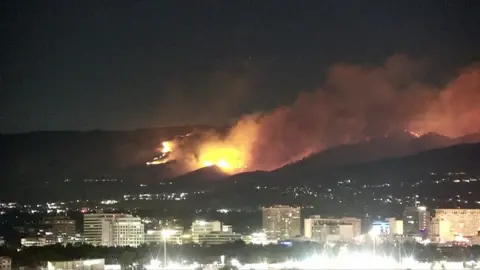 A wildfire burns in the hills in behind Reno, Nevada