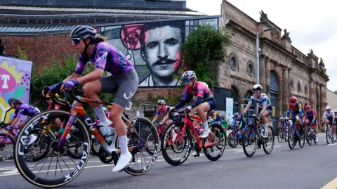 PA Media Among the landmarks the cyclists passed was a mural honouring architect Charles Rennie Mackintosh  