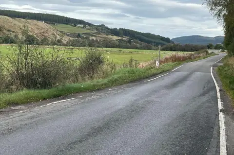 Road at Littlemill near the scene of Wednesday's crash. There is farmland with sheep on one side.