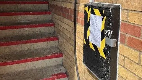 Cambs Police A police closure notice is taped to a utilities cupboard on a brick wall. There are steps in the background.