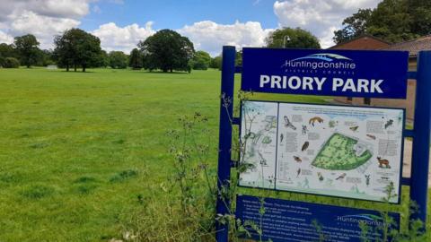 Sign for Priory Park and a field in the background