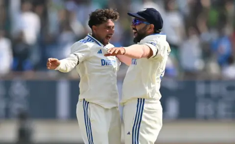 Getty Images Kuldeep Yadav of India celebrates with captain Rohit Sharma after taking the wicket of Ben Duckett of England during day three of the 3rd Test Match between India and England at Saurashtra Cricket Association Stadium on February 17, 2024 in Rajkot, India.