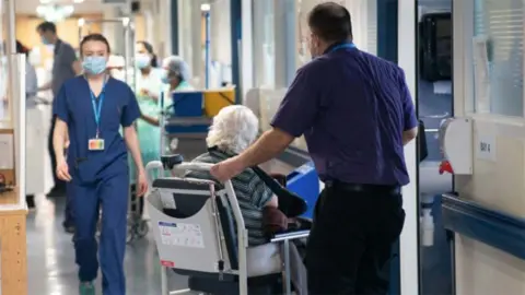 Older patient in a wheelchair in hospital corridor