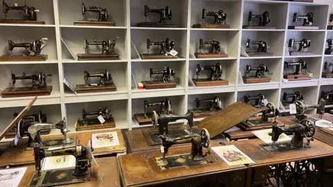 Dozens of sewing machines of different designs fill the shelves at a museum in Somerset