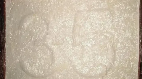 National Crime Agency/PA Wire A block of plastic-wrapped white cocaine which has two raised numbers in its middle reading 35.