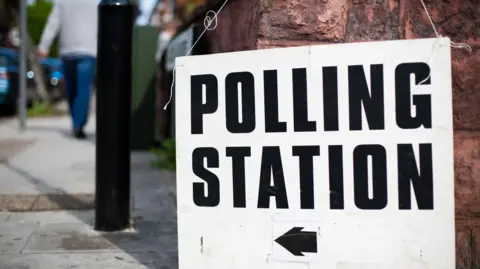 Getty Images A white polling station sign with an arrow pointing tothe left