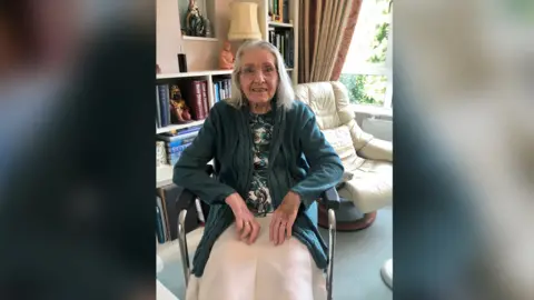 Joy Roberts/PA Wire Irene Wright in a wheelchair. She has grey hair down to her shoulders and glasses, in a green cardigan, a flowery top and a beige skirt