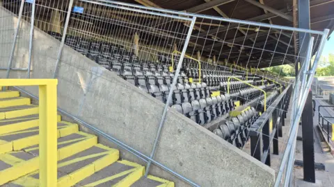 The main stand at the Harvey Hadden Stadium, with fencing preventing access.