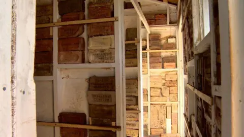 Shelves of bricks from floor to ceiling.