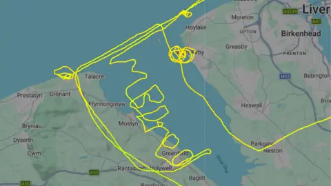 Bored spelt out in green letters on flight tracking app flightradar24 over a mape of North Wales