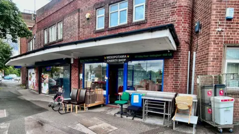 Mesopotamia Outside of the shop, a two storey brick building, which has various pieces of furniture outside