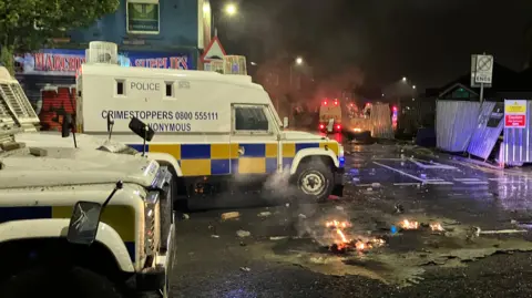 BBC Sandy Row with police land rovers during disturbances 