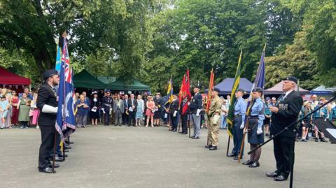 Armed forces organisations line up carrying ceremonial flags