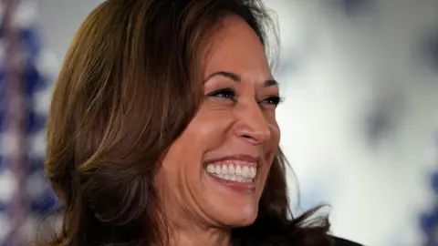 Reuters Close headshot of Kamala Harris in profile grinning as she looks to the left of the camera