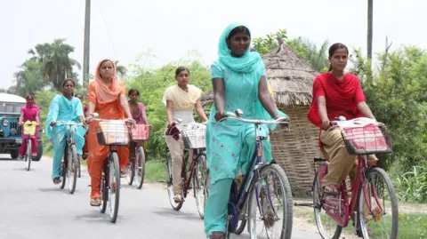 Hindustan Times via Getty Images Girls pedal their way back to Khanpakri, 7 kms fom the High School Desari in Vaishali district in Bihar after attending classes on the bicycles provided under the cycle scheme of the state government. 