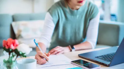 A woman doing home finances on her laptop