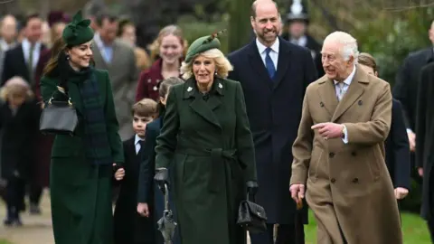 Getty Images Sang Raja, mengenakan jas berwarna krem, Ratu Camilla, mengenakan jas dan topi hijau, Putri Wales, mengenakan jas yang sama, dan Pangeran Wales, mengenakan jas dan dasi, tersenyum saat mereka tiba untuk kebaktian tahunan di Gereja St Mary Magdalene, Norfolk. 