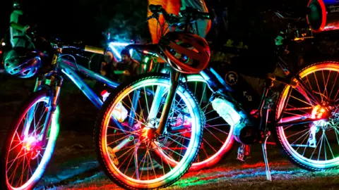 Two bicycles covered in colourful lights