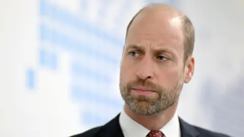 Prince William looking away from the camera. He looks like he's listening to someone.