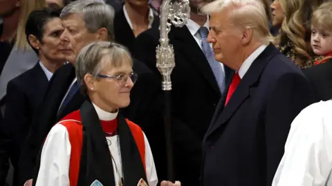 Right Rev. Mariann Edgar Budde walking past President Trump