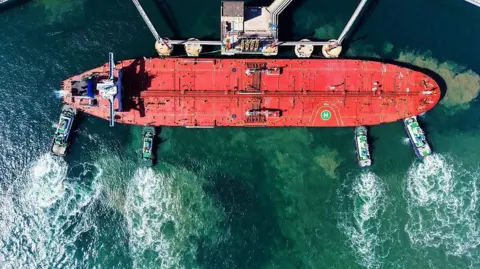 NurPhoto via Getty Images A cargo ship loaded with imported crude oil docks at the crude oil terminal berth in Qingdao, Shandong Province, China, on February 16, 202