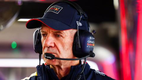 Red Bull design chizzle Adrian Newey looks on durin a race