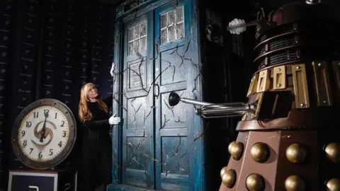 PA Media A Propstore employee looks at a screen-matched cracked Tardis from Doctor Who's series 13: New Year's Eve special - 'Eve of the Daleks'