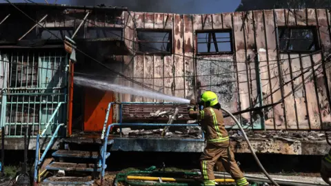 EPA - Un vigile del fuoco combatte un incendio causato da un missile lanciato da Hezbollah contro un deposito di emergenza a Kiryat Shmona, nel nord di Israele (24 settembre 2024)