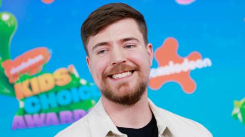 MrBeast aka Jimmy Donaldson at the Nickelodeon Kids Choice Awards. Jimmy has short brown hair and a short brown beard. 