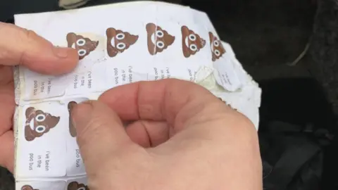BBC/Seb Cheer A sheet of stickers reading "I've been in the poo bus" with poo emojis next to the text.