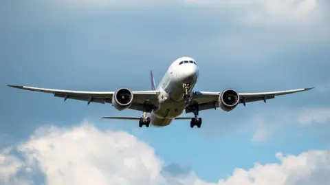 Getty Images A passenger jet seen taking off against a blue sky