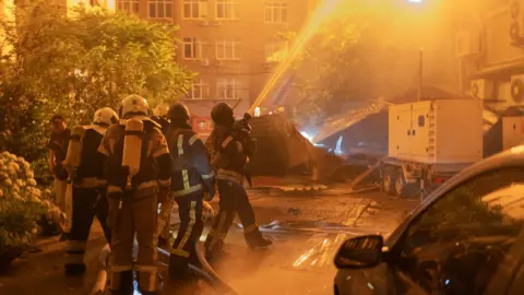 Fire fighters hosing down a fire overnight 
