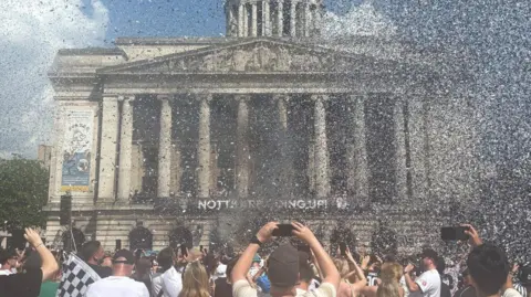 BBC A sky filled with black and white confetti in front of the Nottingham Council house