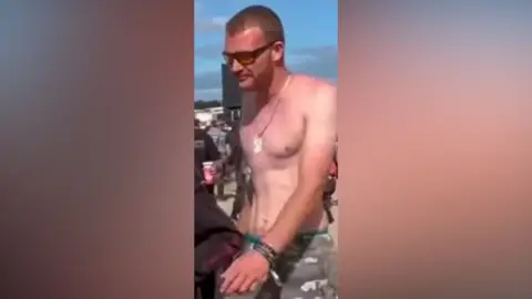 A shirtless man wearing sunglasses
