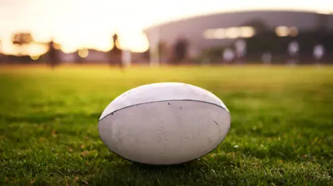 Closeup shot of a white rugby ball placed on grass in a field