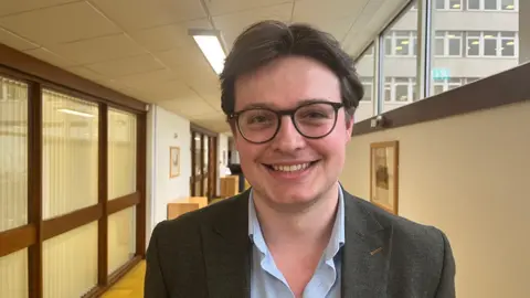 A man in a jacket and glasses