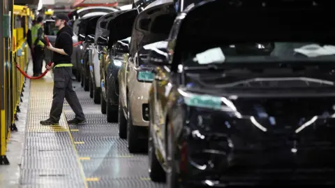 A member of staff works on the production line at Jaguar Land Rover’s factory in Solihull, Britain, 15 December, 2022.