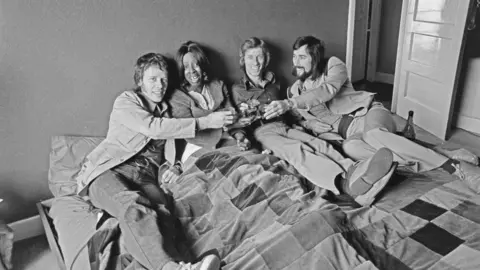 Getty Images Herbie Flowers and the rest of Blue Mink lying on a bed during a photoshoot