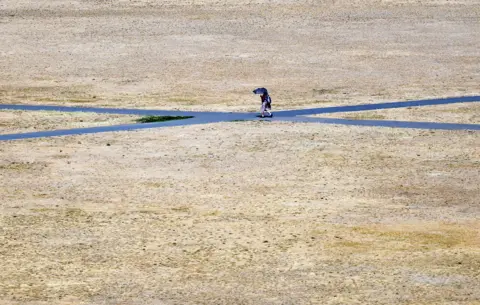 EPA A person walks through parched park lands at Greenwich in London, Britain, 24 July 2026.