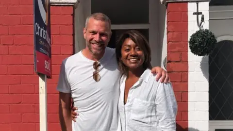 Tom Bodfish and Jaxx Nelson outside a red brick terraced house. They are both wearing white shirts.