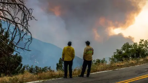 Getty Images Firefighters watch the smoke as the Line Fire burns in the foothills of the San Bernardino Mountains