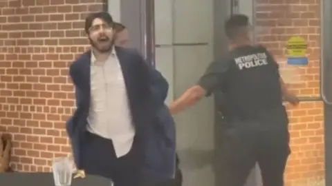 Man being taken away by police
